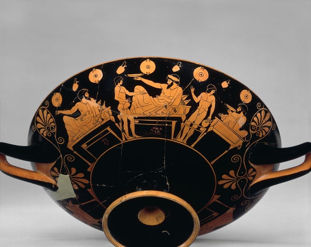Athenian red-figure drinking cup depicting a reclining banqueter playing kottabos