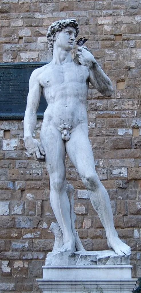 Marble replica of David outside Palazzo Vecchio on a high pedestal in Piazza della Signoria.