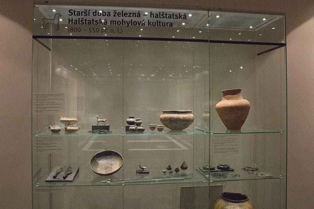 Museum showcase with Early Iron Age Hallstatt-culture artifacts including vessels and ornaments.