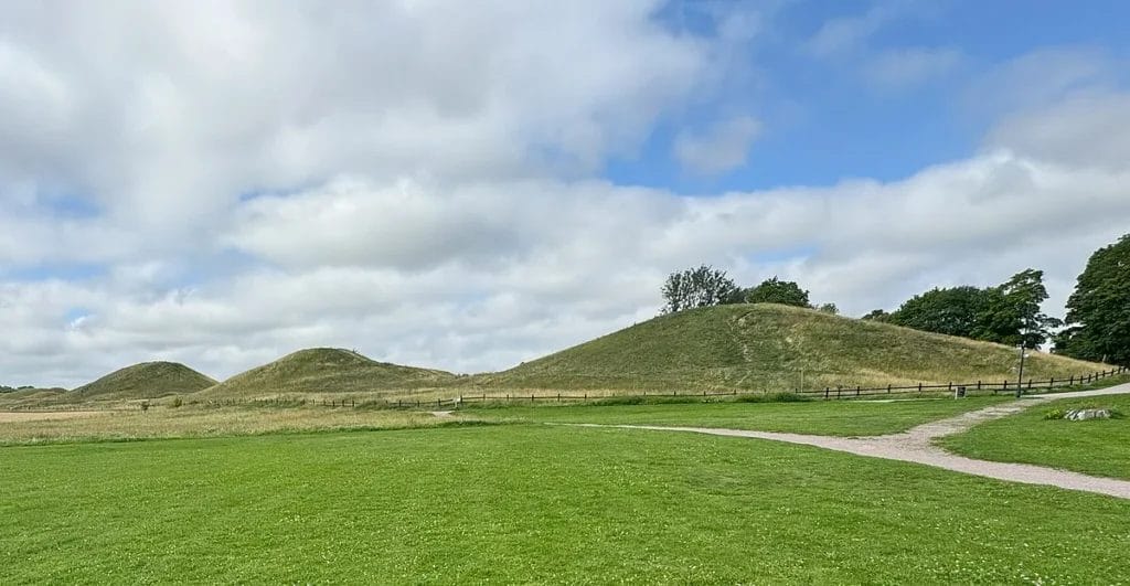 The three large royal burial mounds with the medieval church of Gamla Uppsala in the background.