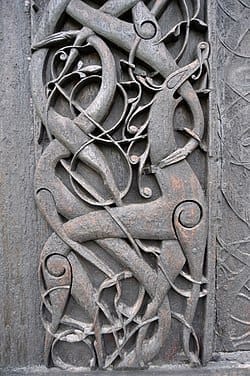 Stave church portal carving with a bound wolf motif
