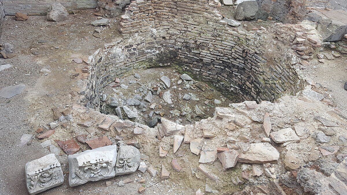 Masonry lime kiln built into a slope with firing chamber.