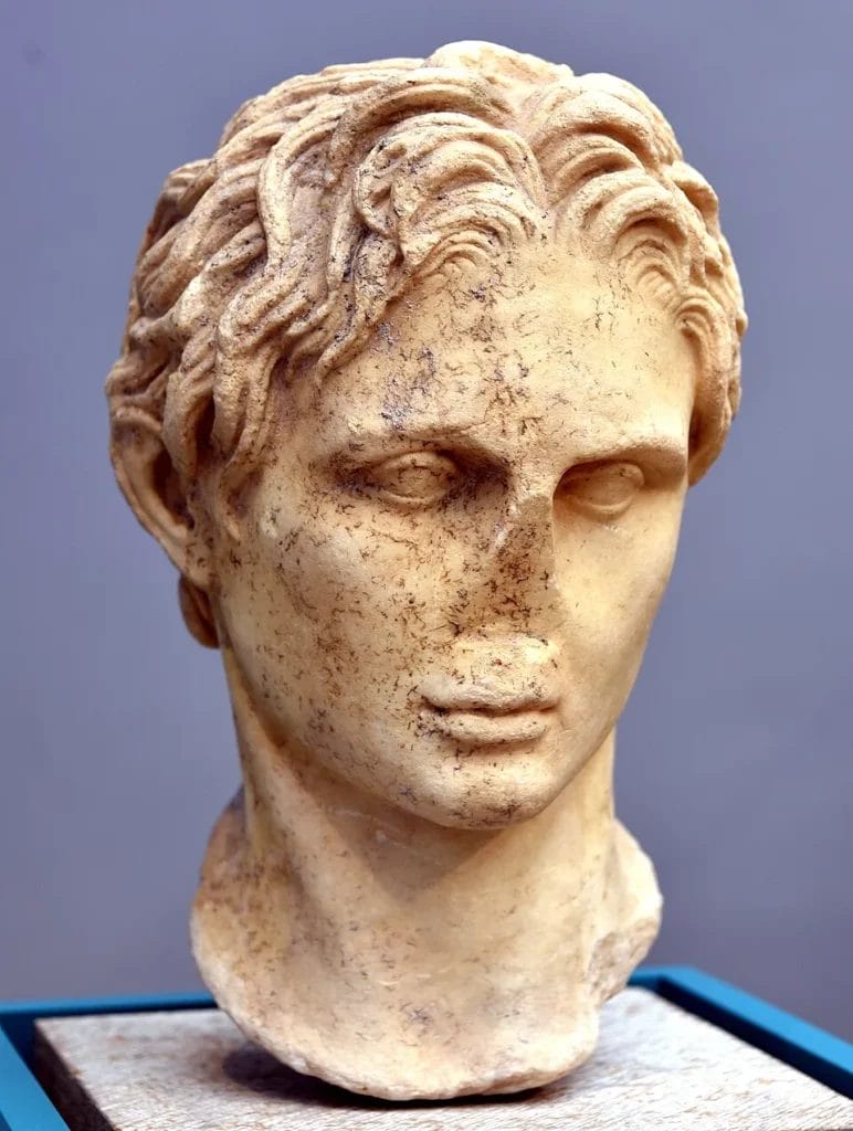 Marble head of Alexander the Great with the nose broken diagonally across the bridge.