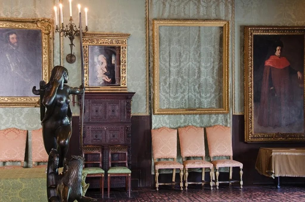 Two empty gilded frames hanging on a wall where stolen paintings once were displayed.