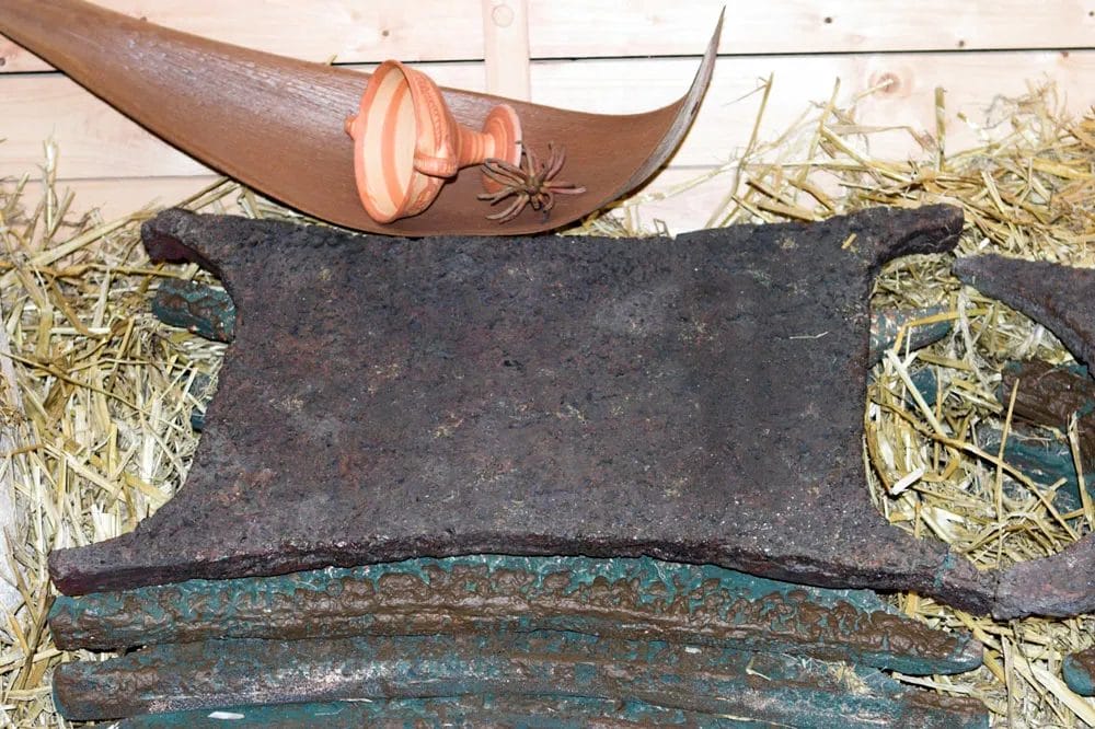 Oxhide-shaped copper ingot with four corner ears, photographed in an Uluburun exhibition case.