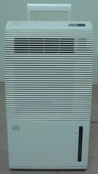 White portable dehumidifier unit with front grill and water reservoir
