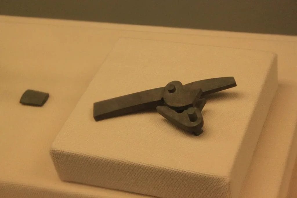 Bronze crossbow trigger mechanism from the Qin dynasty on a museum mount, with components visible