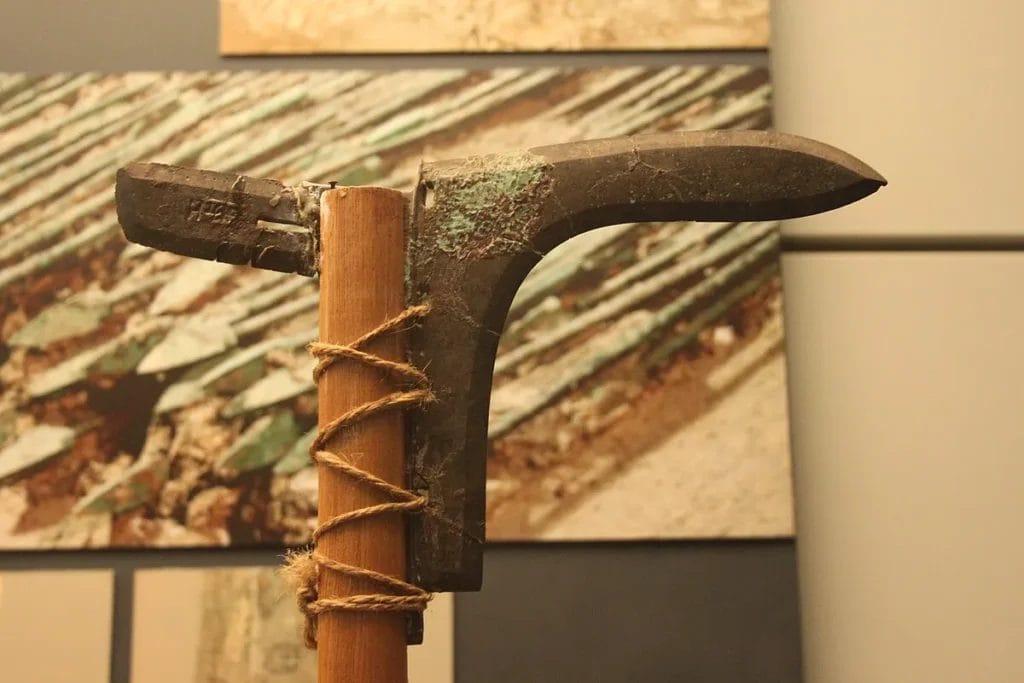 Qin bronze dagger-axe with lateral blade and socket, displayed in a museum