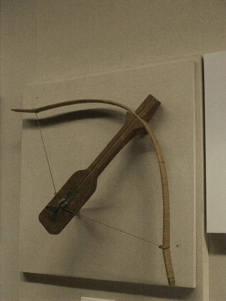 Detailed photograph of a Qin bronze crossbow mechanism with interlocking parts