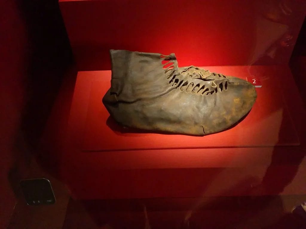 isolated Roman leather shoe on stand in museum case
