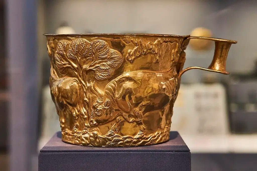 Museum image of a Vapheio cup showing a bull capture episode used to contrast herding violence with controlled leaping.