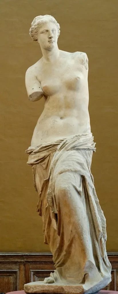 The Venus de Milo statue viewed from the front, showing missing arms but intact face.