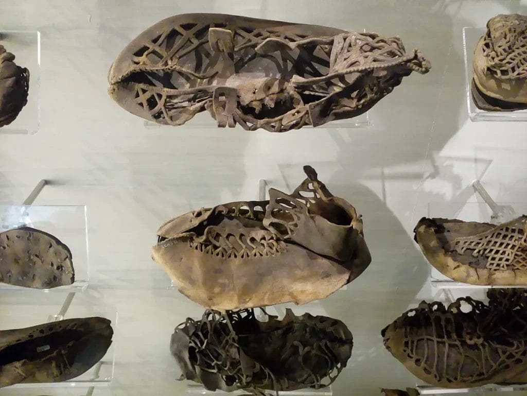 museum display with many Roman shoes arranged in rows