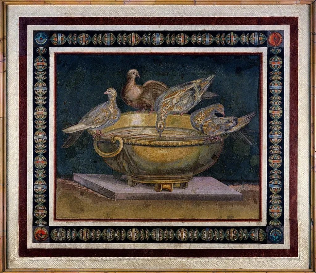 Four doves perch on a bronze bowl beside scattered seeds