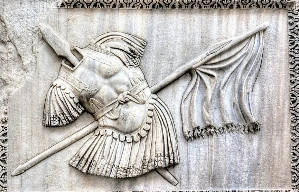 Roman trophy monument showing captured weapons and armor arranged as religious offering.