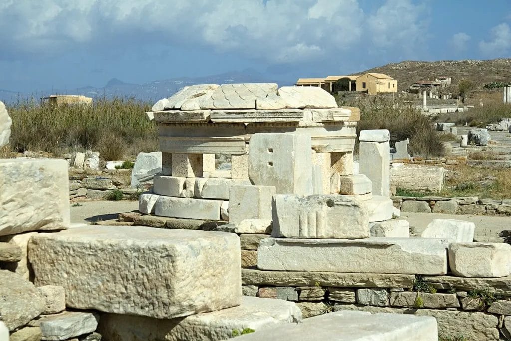 Ancient stone altar platform from the sanctuary of Hermes on Delos where centuries of animal sacrifices left archaeological deposits of charred bones and chemical traces.