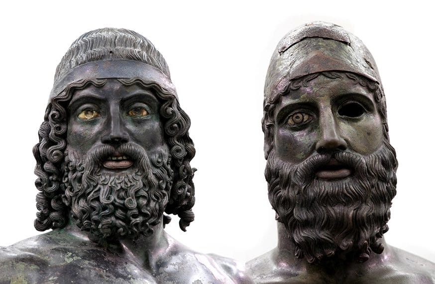 Close-up faces of Riace Bronzes showing bearded warriors with green bronze patina and intricate hair detail