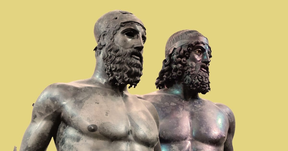 Two Greek bronze warrior statues standing side by side with green patina from underwater preservation